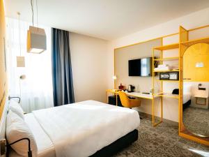 锡比乌Ibis Styles Sibiu Arsenal的配有一张床和一张书桌的酒店客房