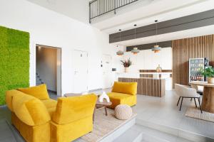略夫雷加特河畔奥斯皮塔莱特巴塞罗那奥纳生活酒店的一间带黄色家具的客厅和一间厨房