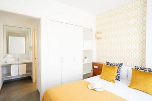 略夫雷加特河畔奥斯皮塔莱特巴塞罗那奥纳生活酒店的一间卧室配有一张带黄色枕头的床和一间浴室