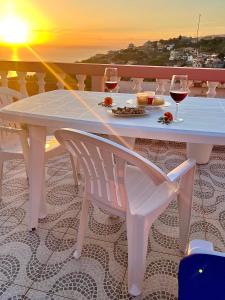 里韦拉布拉瓦Blue Paradise Apartment的白桌椅、酒杯和日落
