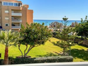 马拉加Apartamento con vistas al mar a 1 min de la playa的享有棕榈树公园和建筑的景色