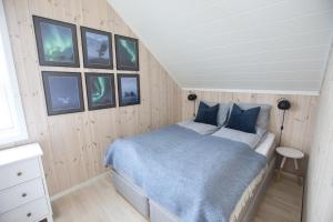 巴尔斯塔Cabin in Lofoten with spectacular view的卧室配有一张床,墙上挂有图片