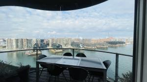 哥本哈根ApartmentInCopenhagen Apartment 1591的阳台配有桌椅,享有水景