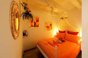 安科纳Lillac Cottage的一间卧室配有带橙色枕头的床