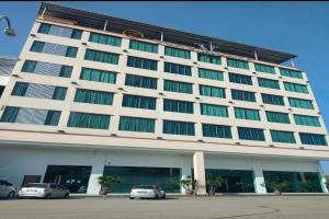 Muadzam ShahOYO 90934 Tong Villion Hotel的一座大型建筑,前面有汽车停放