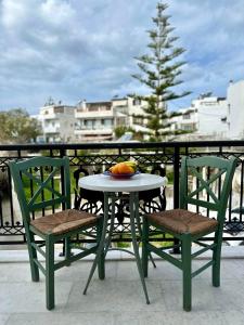 纳克索乔拉Ammosis Inn的阳台上配有一张桌子和两把椅子,并备有水果