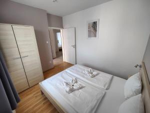 布达佩斯科文广场公寓及套房的一间白色卧室,床上配有2条白色毛巾