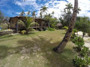 Nanuya LailaiGold Coast Inn - Adults Only的前面有棕榈树的房子