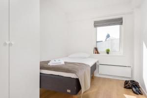 奥斯陆美卓斯托公寓的一间小卧室,配有床和窗户