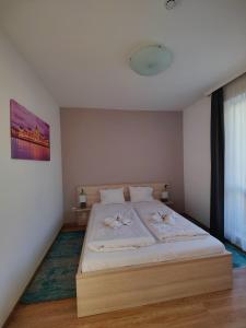 布达佩斯科文广场公寓及套房的一间卧室配有一张带白色床单的大床
