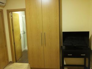 马拉加曼纽拉太太旅馆的一间配有电视的房间里的大型木柜