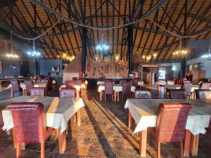 OpuwoOpuwo Country Lodge Campsite的大楼内带桌椅的用餐室