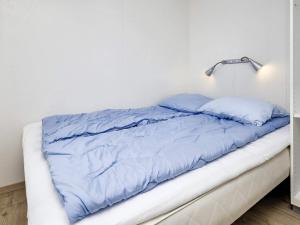 博恩瑟Holiday home Bogense XLV的白色客房内的一张带蓝色床单的床
