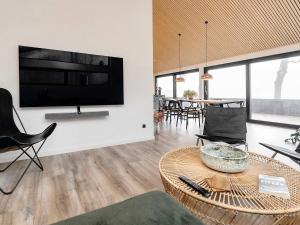 腓特烈港Holiday home Frederikshavn IV的客厅配有壁挂式大屏幕平面电视