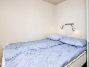 博恩瑟Holiday home Bogense XLVIII的一张带蓝色枕头的床