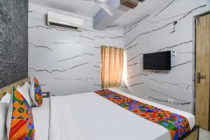 SāntrāgāchiFabExpress Subh Residency的一间卧室配有一张床,墙上配有电视