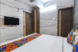 SāntrāgāchiFabExpress Subh Residency的一间卧室配有一张床,墙上配有电视