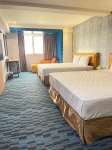 高雄逸亭商旅 的酒店客房,设有两张床和一张沙发