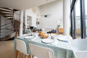 凡尔赛Villa Corneille - Welkeys的一间带桌子和白色椅子的用餐室