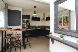 沙特尔Le Saint-Brice的厨房配有黑色橱柜、凳子和镜子