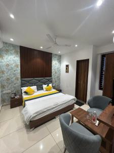 卢迪亚纳THE LUXURY PLATINUM INN --Luxury Deluxe Rooms -- Chandigarh Road的卧室配有一张床和一张桌子及椅子