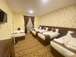 麦加مرجان أنوار الروضة的一间酒店客房,设有三张床和一台平面电视