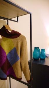 库尼奥Ars Nova的挂在桌子上带花瓶的衣架上的毛衣