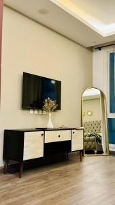 拉合尔Luxury apartment in Gold Crest Mall 1 bed的一间带电视和镜子的客厅