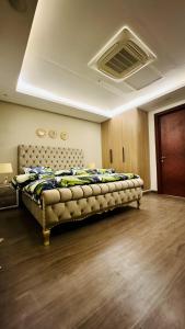 拉合尔Luxury apartment in Gold Crest Mall 1 bed的一间带一张床铺的卧室,位于带天花板的房间内