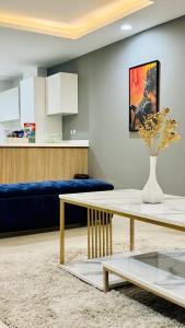 拉合尔Luxury apartment in Gold Crest Mall 1 bed的客厅配有桌子和蓝色沙发