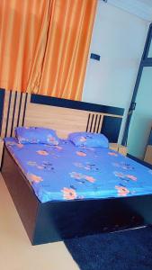 科托努Charly-hôtes 02的一张带鲜花的蓝色棉被的床