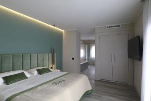 科内利亚诺黎莱斯里贝图雷酒店的一间卧室配有一张大床和一台平面电视