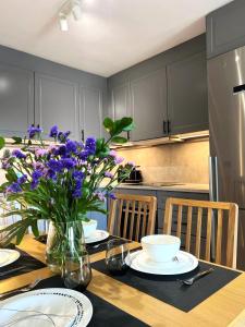 法纳贝海滩Apartamento Amarillo Oceanview的厨房配有带紫色花卉的花瓶桌