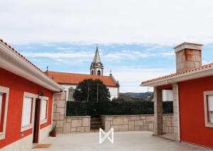 比索达雷加MyStay - Oliveira Douro House的从两栋建筑中欣赏到教堂的景色