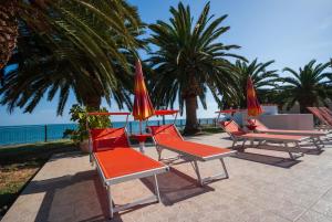 马蒂纳塔Villa Lucia的海滩上一组带遮阳伞的椅子