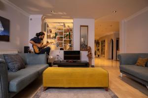 伊斯坦布尔Studio in a social environment的一个人在客厅里弹吉他