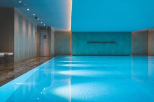 泰晤士河畔里士满Harbour Hotel & Spa Richmond的蓝色灯光的房间的游泳池