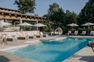 蒙巴鲁佐拉维拉酒店的一个带躺椅和遮阳伞的游泳池