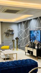 拉合尔One Bed Appartment in GoldCrest Mall and residency DHA Lahore的客厅配有蓝色的沙发和电视