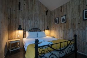 富尔纳斯WelcomeBuddy - Quinta D'Água的一间卧室设有一张床和木墙