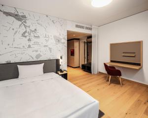 帕德博恩IntercityHotel Paderborn的卧室配有白色的床和电视