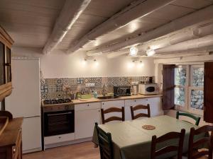 科迪加纳富希奥德米洛斯乡村民宿的厨房配有桌子和炉灶。 顶部烤箱