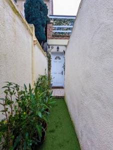 勒阿弗尔Maison atypique avec garage 2 roues - Proche Gare的一条有白色门和一些植物的小巷
