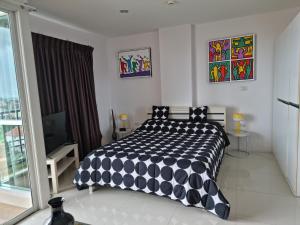 南芭堤雅Diamond Suites Resort的卧室配有黑色和白色的被子。