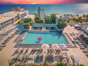 好莱坞Tropical Oasis - Rooftop Pool- Near Beach - Gym的享有带椅子和遮阳伞的游泳池的上方景致