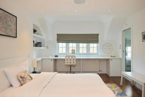 伦敦The Clapham Crib - Spacious 4BDR House with Patio的白色卧室配有床和书桌