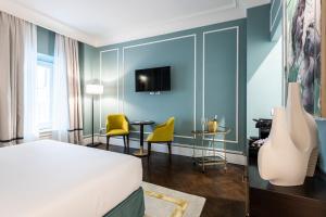 佛罗伦萨Glimpse Hotel的酒店客房带一张床、一张桌子和椅子