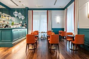 佛罗伦萨Glimpse Hotel的用餐室配有橙色椅子和桌子