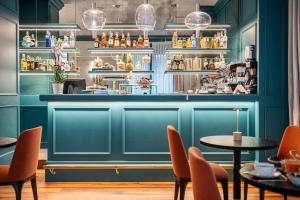 佛罗伦萨Glimpse Hotel的餐厅拥有蓝色的墙壁和桌椅