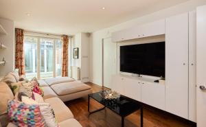 伦敦The Clapham Crib - Spacious 4BDR House with Patio的带沙发和电视的客厅